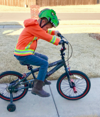 child riding bike with hoodie on