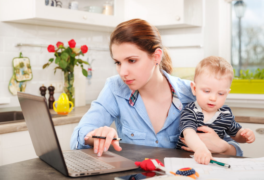 work-at-home mom on laptop holding a toddler