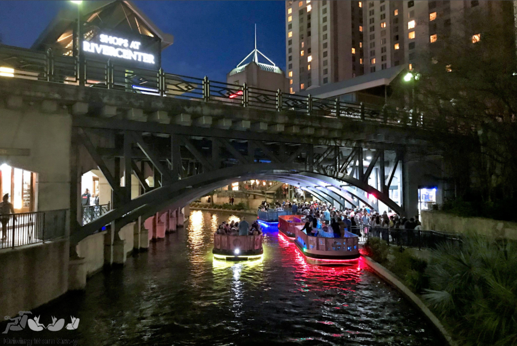 Boats at night with lights on San Antonio riverwalk for the go rio river cruises riverboat tour