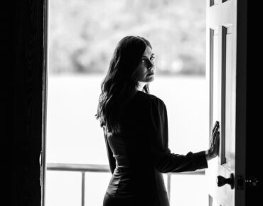 woman opening door with somber face